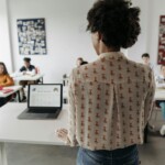 Enseignant consultant sa messagerie académique sur un ordinateur portable en salle des professeurs