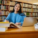 Étudiant connecté à l'ENT Capitole sur un ordinateur portable en bibliothèque universitaire