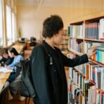 Étudiants connectés sur ordinateur dans une bibliothèque universitaire parisienne