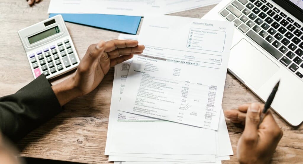 Personne consultant un contrat d'assurance vie devant un ordinateur bancaire