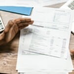 Personne consultant un contrat d'assurance vie devant un ordinateur bancaire