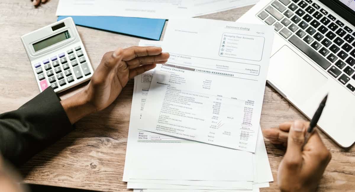 Personne consultant un contrat d'assurance vie devant un ordinateur bancaire