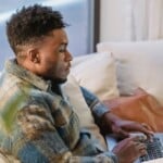 homme consultant ses relevés bancaires sur ordinateur portable chez lui