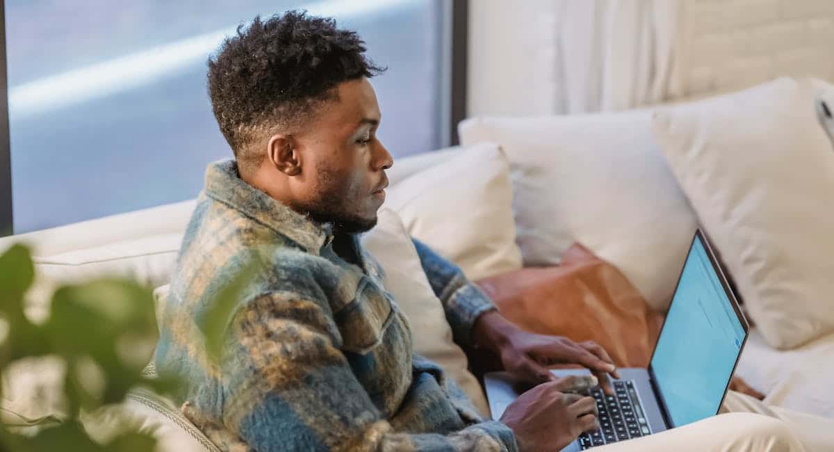 homme consultant ses relevés bancaires sur ordinateur portable chez lui