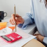 Auto-entrepreneur devant un ordinateur avec documents fiscaux et budget