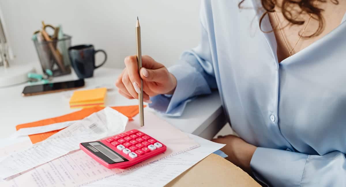 Auto-entrepreneur devant un ordinateur avec documents fiscaux et budget