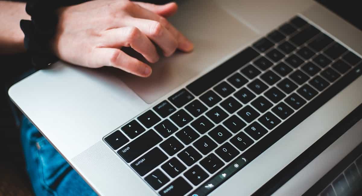 Main posée sur un clavier d'ordinateur consultation espace bancaire en ligne