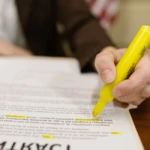 Dirigeant d'entreprise relisant un contrat de travail avec tickets restaurant sur bureau