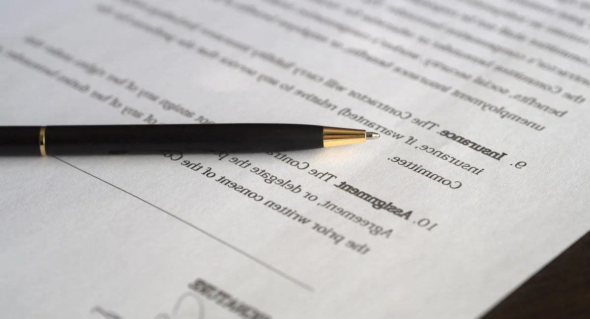 Employeur et salarié signant une convention de rupture dans un bureau professionnel