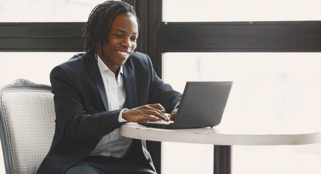 Jeune entrepreneur sur ordinateur, comparant différentes plateformes pour attirer des clients