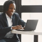 Jeune entrepreneur sur ordinateur, comparant différentes plateformes pour attirer des clients