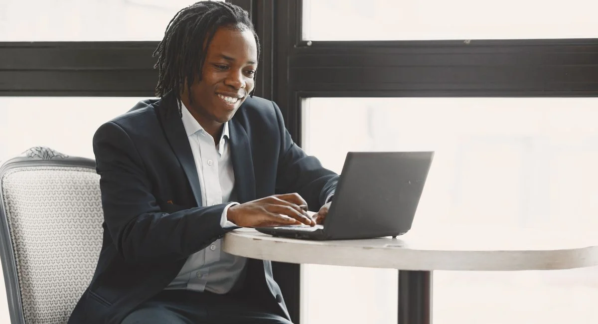 Jeune entrepreneur sur ordinateur, comparant différentes plateformes pour attirer des clients