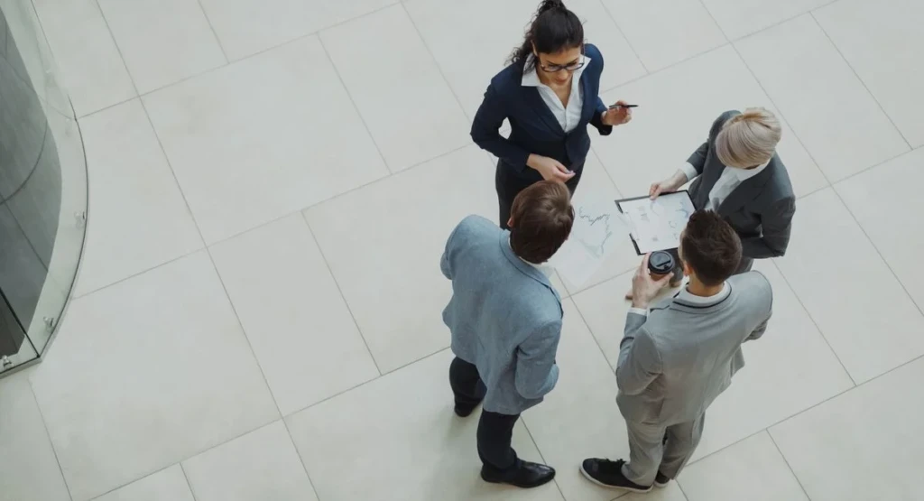 Salle de réunion PME, équipe échangeant sur un tableau de prospection