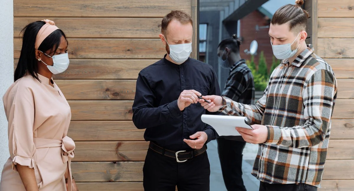 Deux associés signent des papiers devant un immeuble moderne