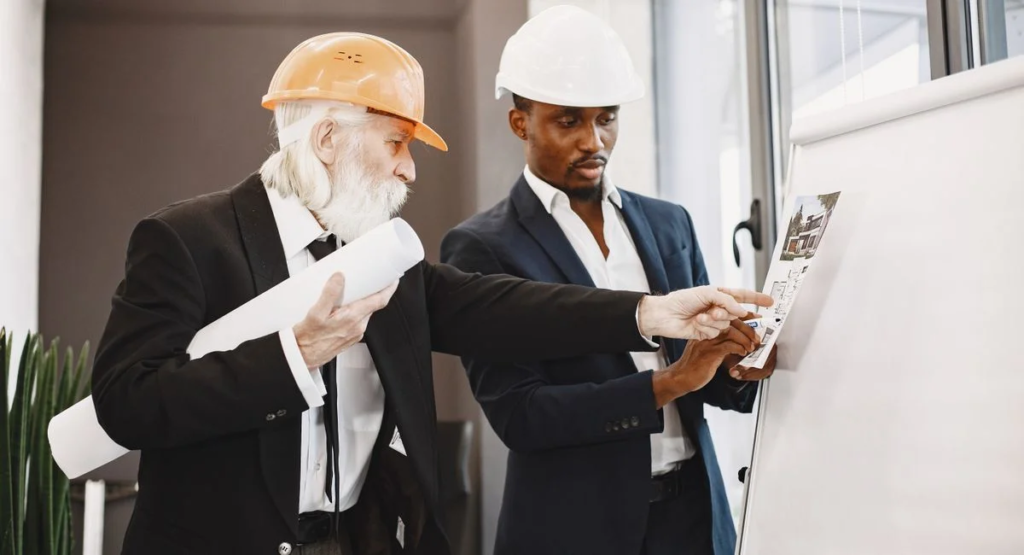 Groupe d’entrepreneurs analysant un plan d’appartement autour d’une table
