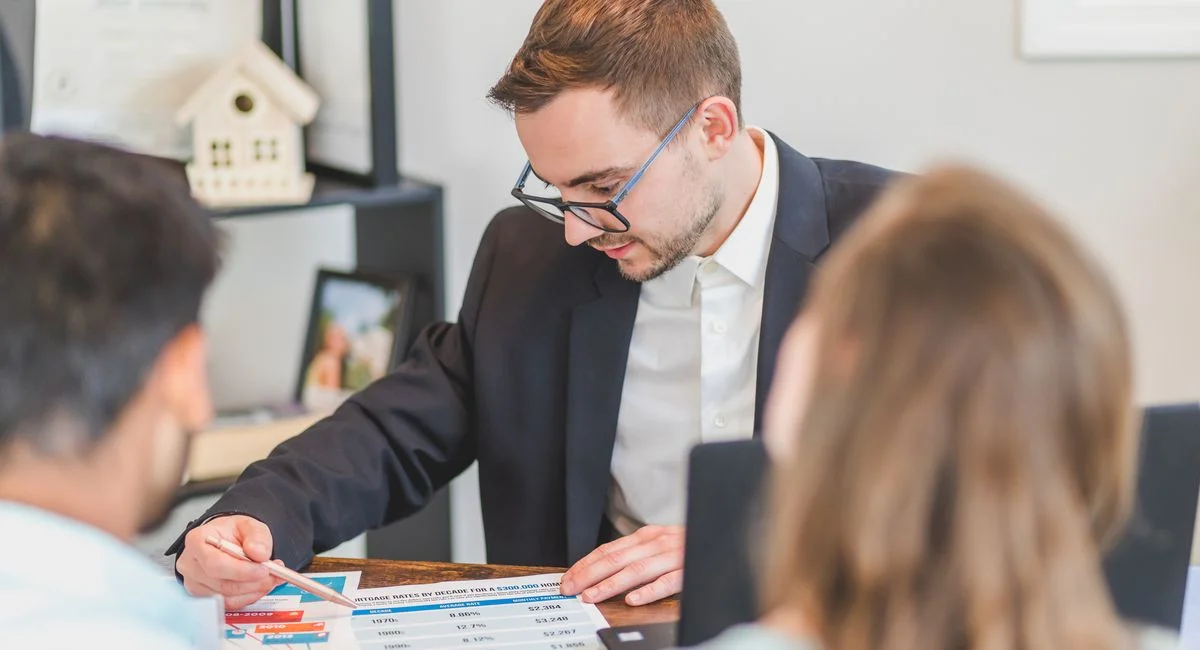 Un entrepreneur analyse des dossiers devant des plans d'immeubles et des graphiques